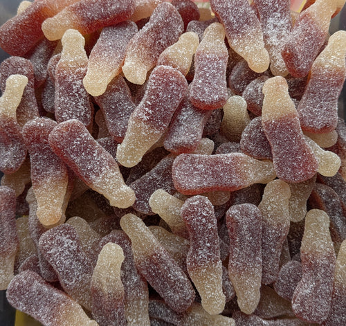 Close-up of a pile of gummy cola bottles with a sugary coating.
