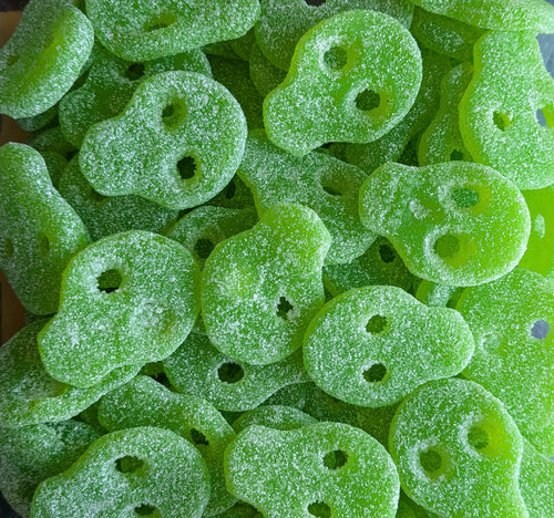 Green skull-shaped gummy candies with a close-up view.