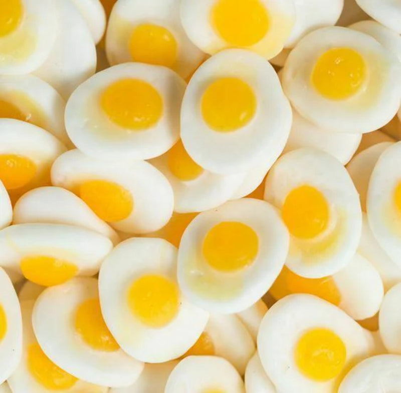 Close-up of fried eggs with runny yolks on a white background - Fresh Sweets | Mayflower Munchies Plymouth